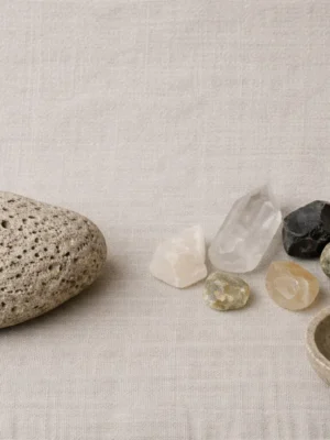 Handcrafted ceramic vessels and ritual tools arranged on a dark, minimalist altar.